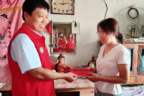 图为陈奇峰给受资助孩子送去爱心助学金